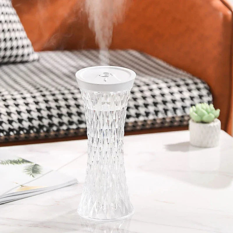 Working cool mist diffuser emitting mist, placed on white marble table near a small succulent
