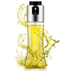Glass oil sprayer bottle with yellow liquid inside, surrounded by splashes of oil against a white background