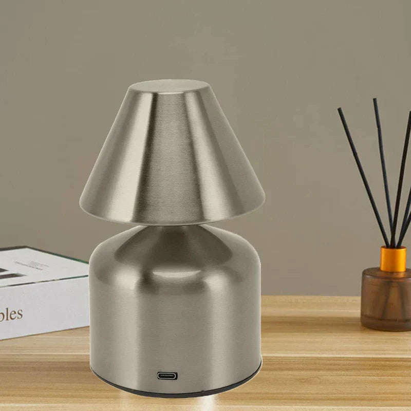 Kleine Tischlampe - bürstsilberne kleine Tischlampe auf einer Holzplatte neben Dekoartikeln