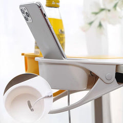 White clip-on cup holder holding a smartphone, with yellow drink bottle in background, shoe box storage