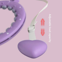 Partial view of a weighted fitness hula hoop and its adjustable strap with heart-shaped weight, labeled Adjustable load capacity