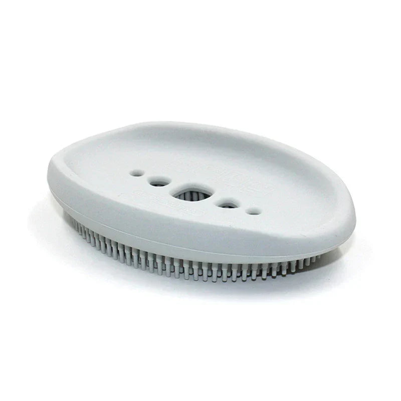 Dish Scrubber Brush - Light gray oval soap dish with five draining holes and small raised bristles along its bottom edge, against a white background