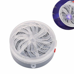 repele animales con ultrasonido - Vista desde arriba de un dispositivo redondo de plástico con rejilla de ventilador en espiral transparente, base gris y botón lateral rojo; un recuadro lo muestra encendido en morado atrayendo mosquitos