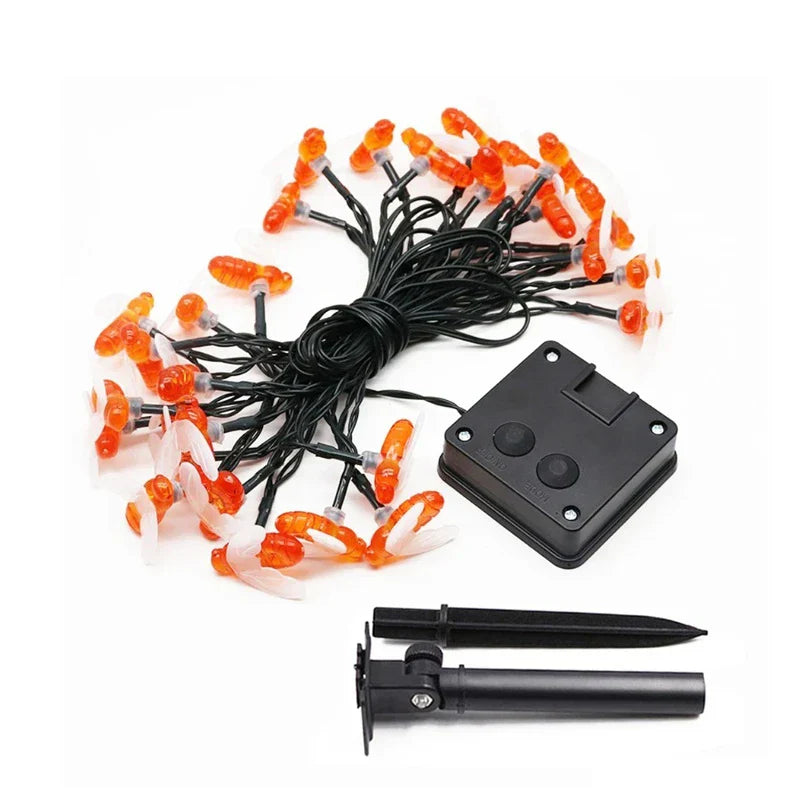 Bee-shaped solar string lights laid out with a control box and ground stake on a white background.