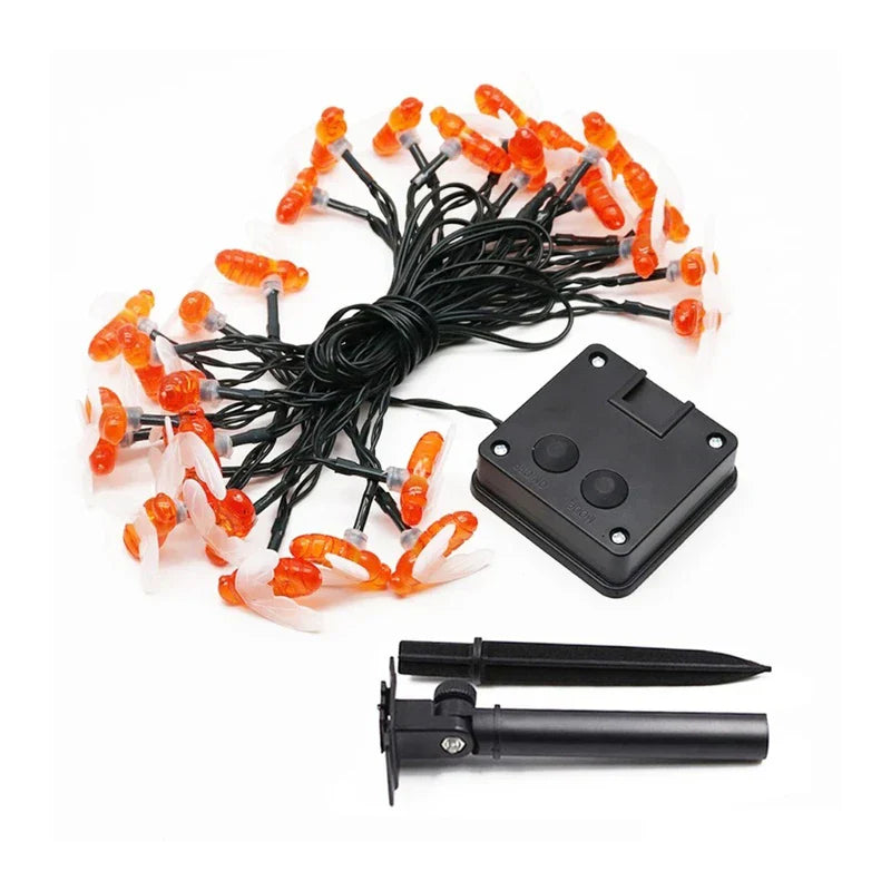 Orange bee string lights displayed with a black control unit and two mounting stakes against white.