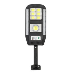 Front view of a solar powered security motion light fixture with LED panels, a control panel, and a mounting bracket on a white background.