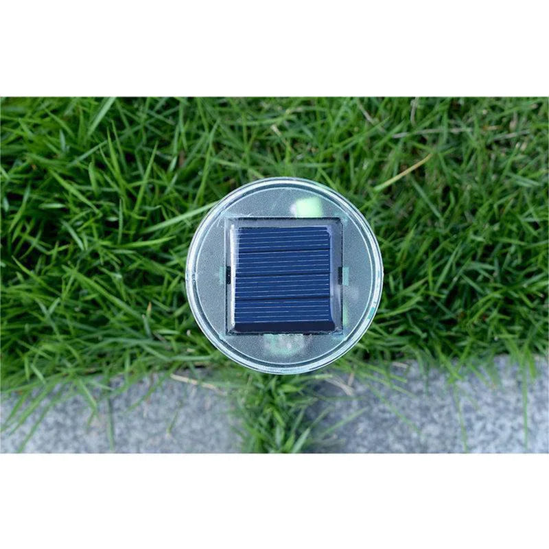 Solar Ultrasonic Mole Snake Repellent Spike - Close overhead view of a small square solar panel on a round device, set over grass and concrete