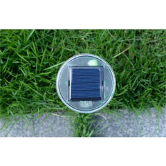 Solar Ultrasonic Mole Snake Repellent Spike - Close overhead view of a small square solar panel on a round device, set over grass and concrete
