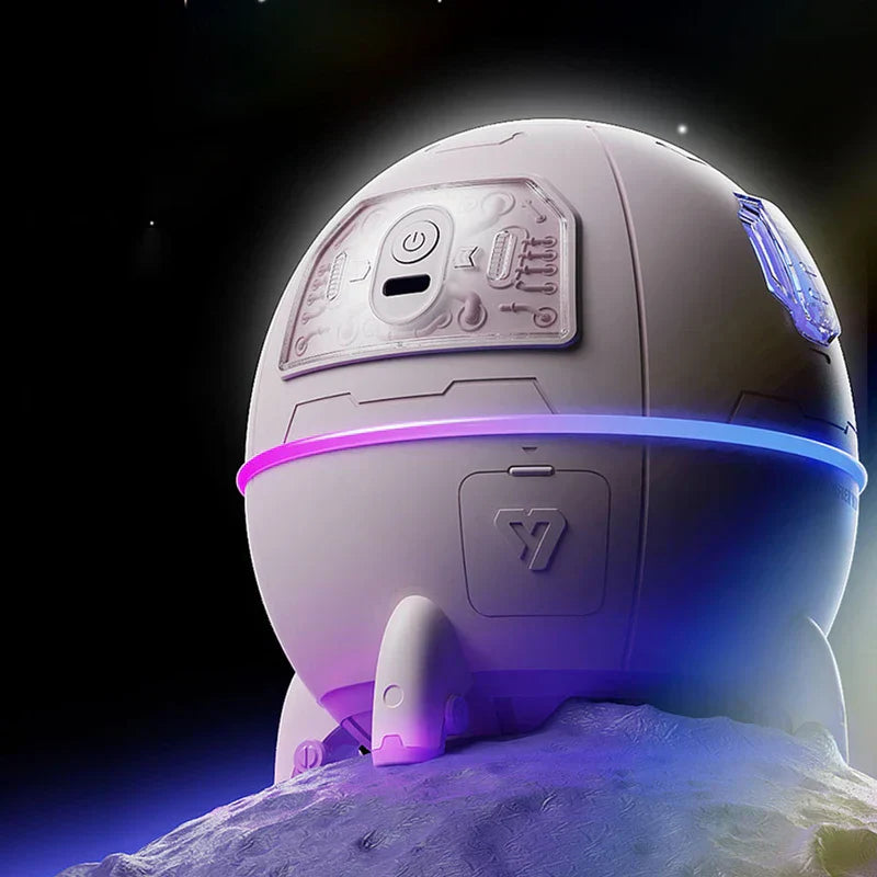Humidifier Diffuser - Back view of the same white spherical astronaut pod device resting on a textured moon-like rocky surface against a starry black background