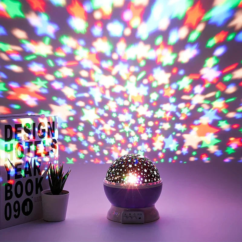 Luz Nocturna de Estrellas: lámpara de proyección de estrellas giratoria que muestra estrellas multicolores en la pared y la superficie, colocada junto a una pequeña planta en maceta y libros apilados