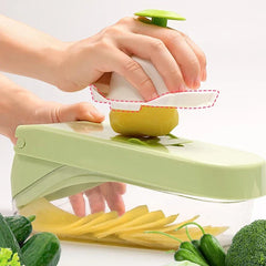 Hands use a food holder to press a potato on a slicer, with cut slices and fresh veggies nearby; this spiralizer vegetable noodle pasta cutter is visibly in use.