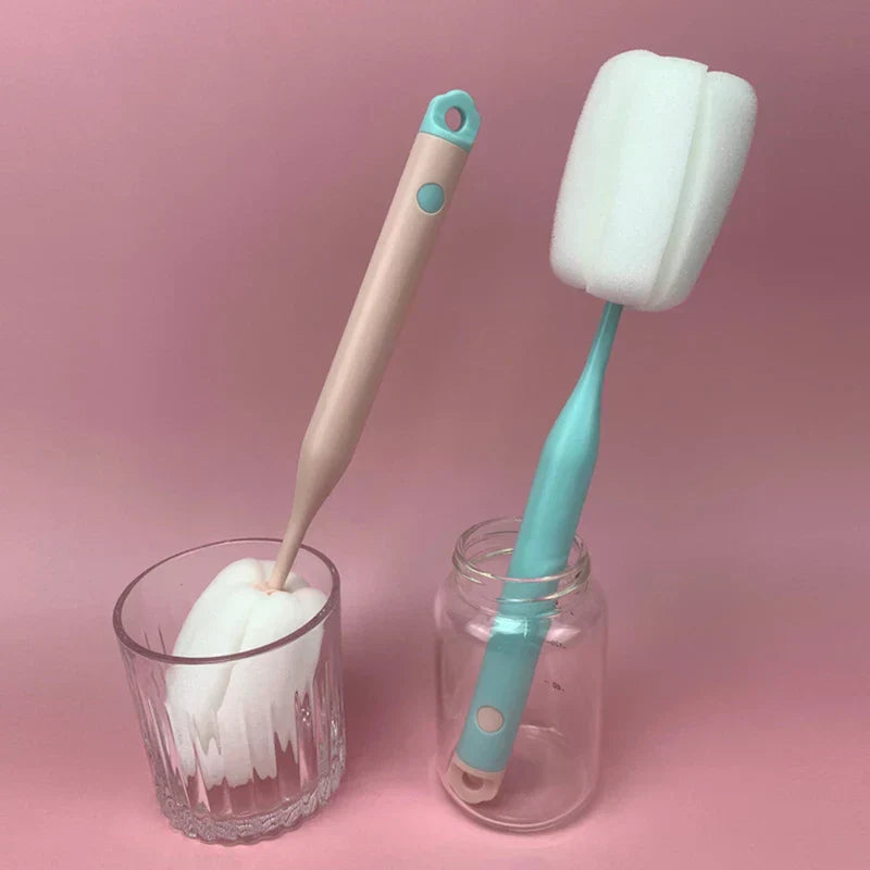 Sponge Bottle Cleaning Brush - Two long-handle sponge brushes placed inside a glass and a clear jar, against a solid pink background.