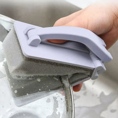 Cepillo de limpieza para ducha: mano sosteniendo el cepillo fregando un plato en un fregadero de acero inoxidable, con espuma en la esponja de limpieza