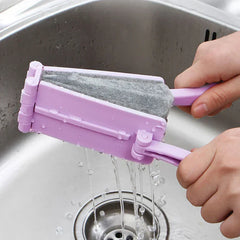 Cepillo de limpieza para ducha: dos manos exprimiendo la herramienta de limpieza sobre un fregadero de acero inoxidable, escurriendo el agua de la esponja