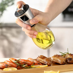 Oil Sprayer Mister - Hand pressing the spray trigger to dispense a fine mist over cooked shrimp and chicken on a wooden serving board