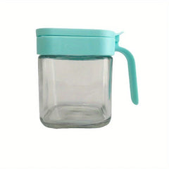 Glass Spice Jar - Empty square glass jar with closed light blue lid and curved side handle, on plain white background.