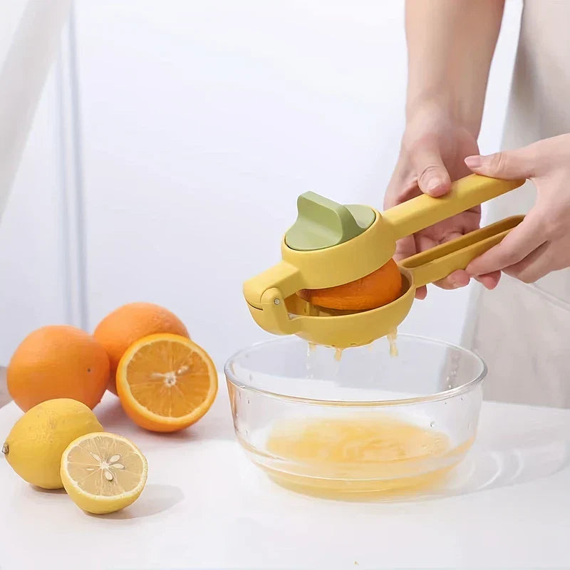 zitruspresse - Hände pressen eine halbe Orange mit einer gelben manuellen Zitruspresse über einer Glasschale, Zitrusfrüchte auf weißer Arbeitsplatte daneben