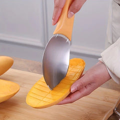 Hand using a mango slicer to cut grid lines into a halved mango held over a wooden cutting board