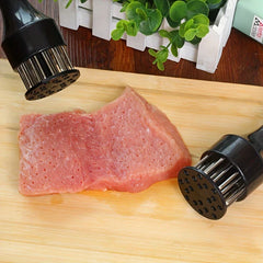 Stainless Steel Meat Tenderizer - Two pronged kitchen tools resting on light wood cutting board next to tenderized raw meat