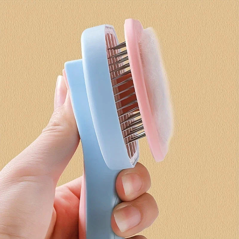 Pet Grooming Comb - Hand holding a pet brush with its cleaning panel pushed up, holding collected pet fur