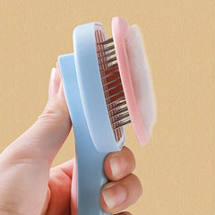 Pet Grooming Comb - Hand holding a pet brush with its cleaning panel pushed up, holding collected pet fur