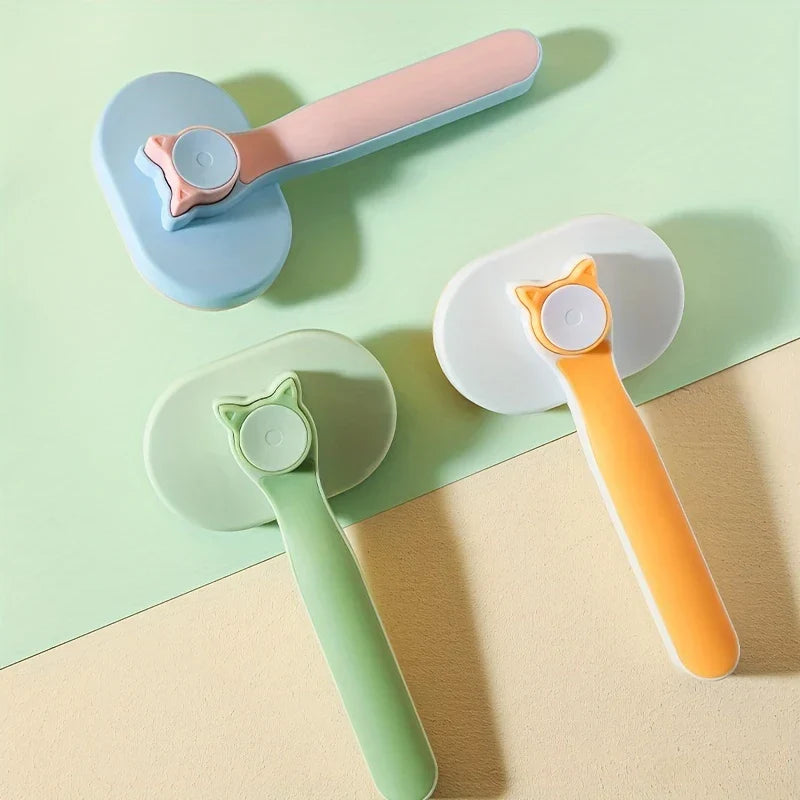 Pet Grooming Comb - Three pet grooming brushes with cat-head accents arranged on a two-tone surface