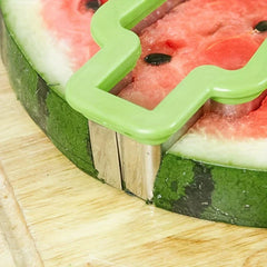 Watermelon Slicer Cutter - Close-up of a green popsicle-shaped cutter pressing into a thick watermelon slice on a wooden cutting board