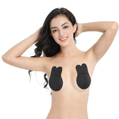 Nipple Concealers - Smiling woman with both hands behind her head, wearing black bunny-style nipple covers