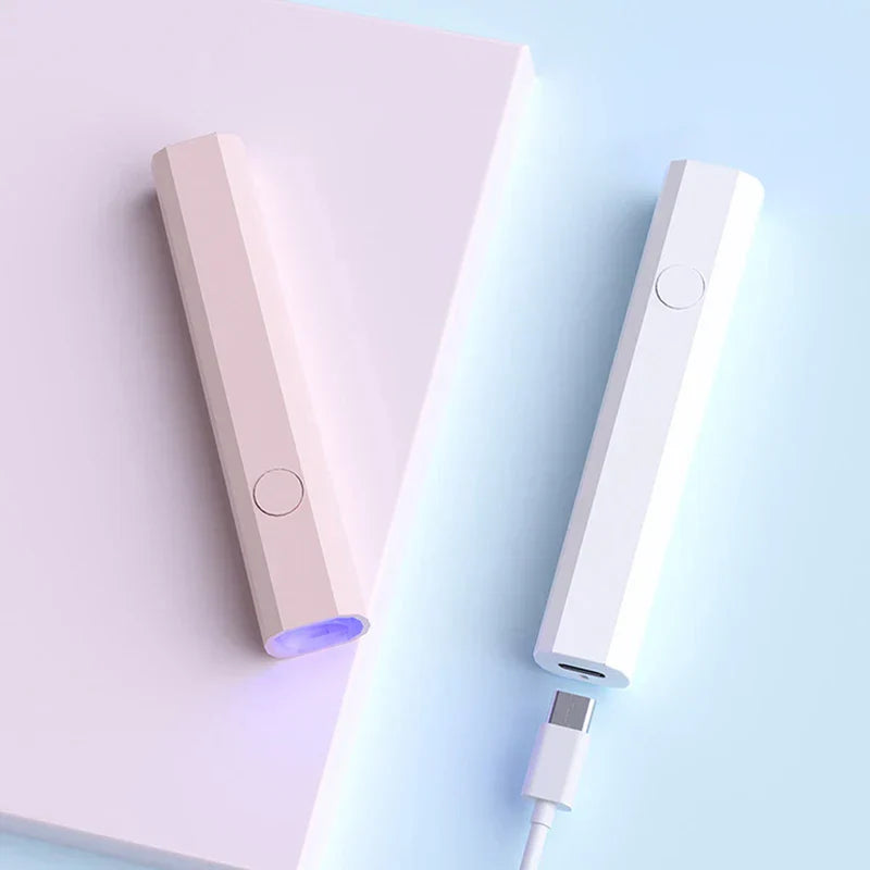 Tira de luces LED para debajo de gabinete: dos dispositivos de luz portátiles (rosa claro y blanco) sobre una superficie, el dispositivo blanco junto a un cable USB-C