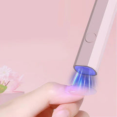 Hand holding finger under purple light device, undercabinet led strip lighting concept shown on pink background with flowers