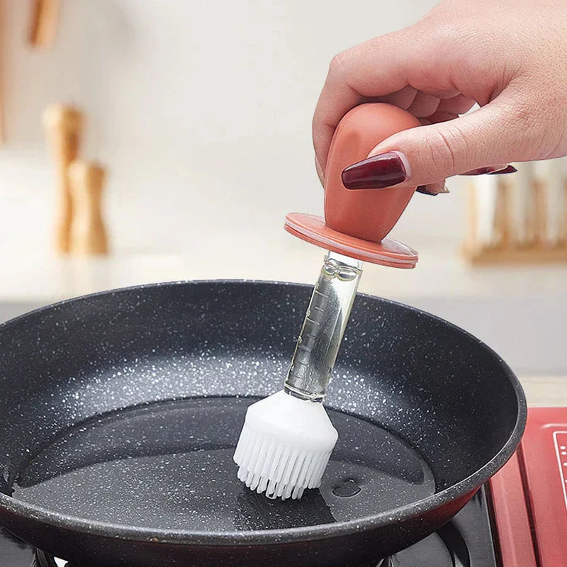 escurridor de vidrios - Mano con esmalte de uñas rojo oscuro sosteniendo un pincel para untar con mango rojo, extendiendo aceite sobre la superficie de una sartén antiadherente negra con motas
