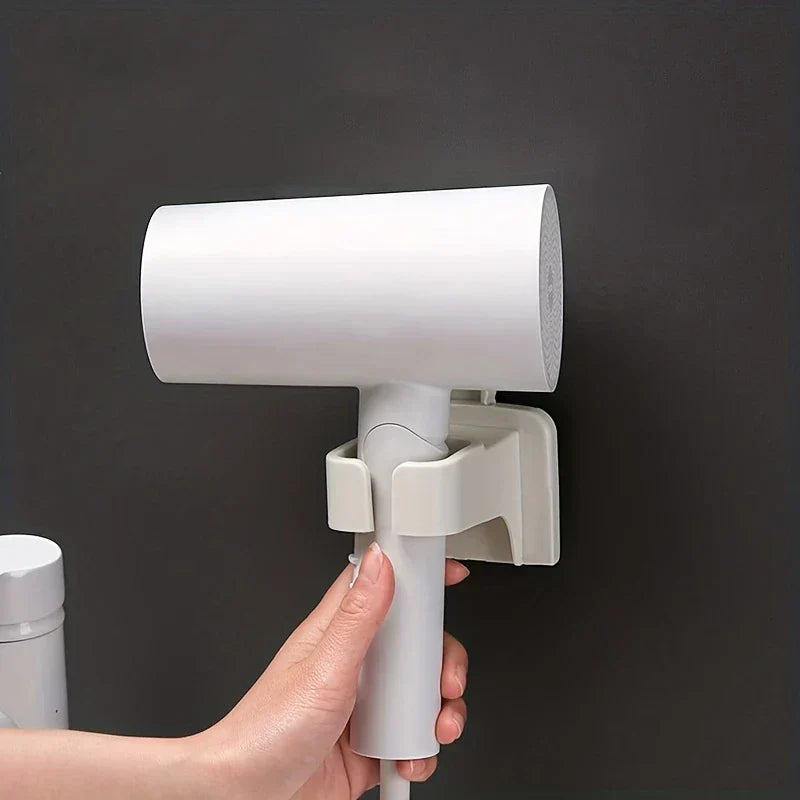 Hair Dryer Holder Wall Mount - Close-up of a hand placing a white hair dryer into an installed white wall holder mounted on a dark wall.