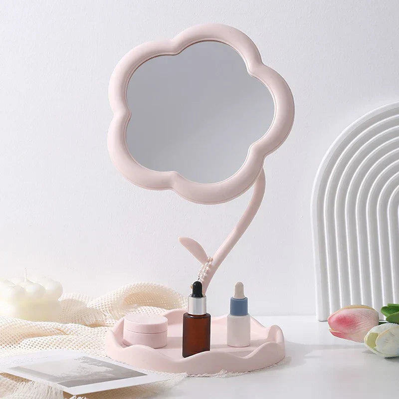 Makeup Mirror - Light pink flower-shaped desktop mirror with tray holding small skincare containers, styled with decor on a white surface