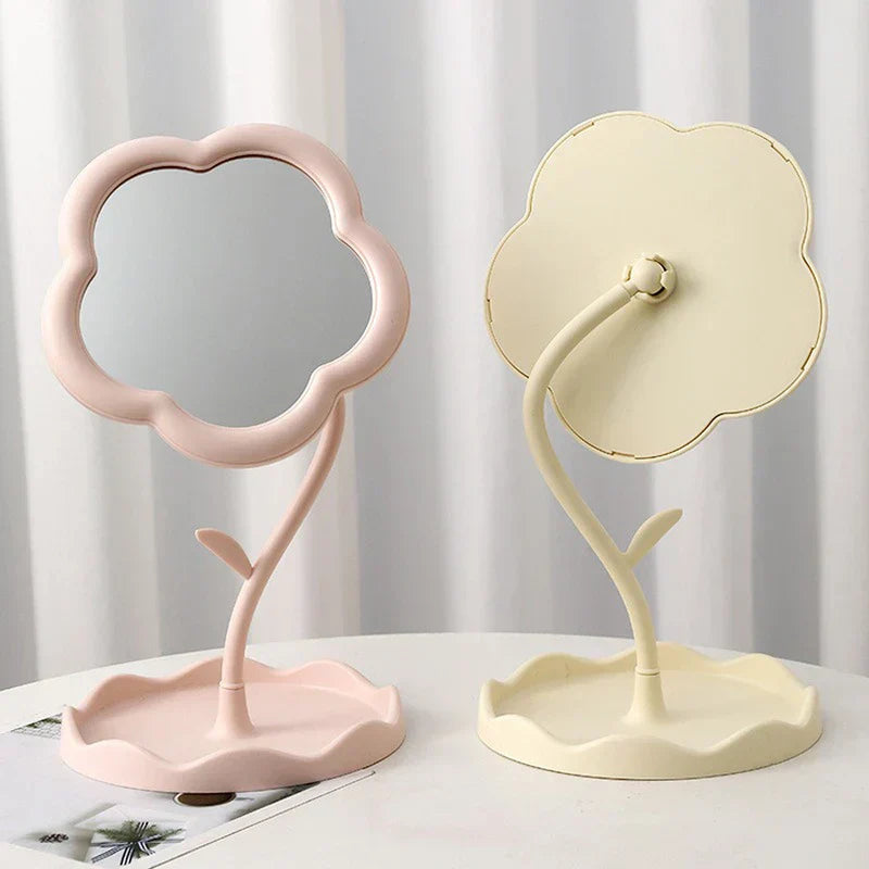 Makeup Mirror - Two flower-shaped desktop mirrors, one light pink facing forward and one cream colored turned to show its back, placed on a white surface