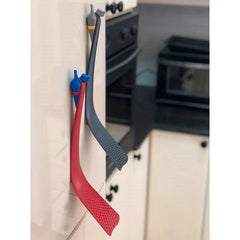 Turner Spatula - Red and dark gray superhero-shaped slotted utensils attached vertically to a refrigerator side
