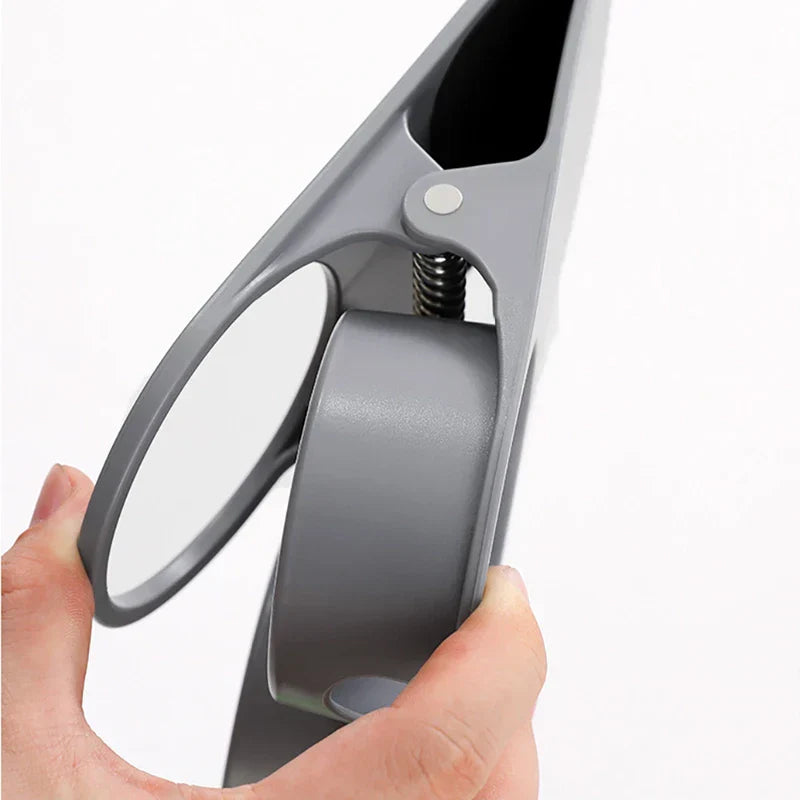 Table Side Drink Clamp Holder - Close-up of a hand holding and squeezing a gray plastic spring-loaded clamp, showing its internal spring and pivot rivet.