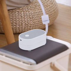 Tea Tray Drainage Pipe - Device placed on a dark tea tray surface with attached clear tubing, set near a woven rattan seat