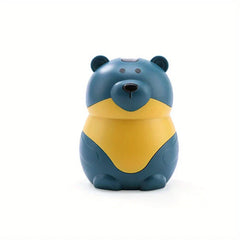 Sujetapalillos con forma de osito de peluche: objeto de plástico con forma de oso de dibujos animados, en color verde azulado con vientre amarillo, vista frontal sobre fondo blanco
