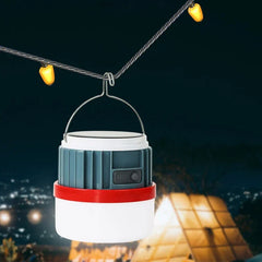 Camping Lantern - Same hanging light suspended from a twisted wire with small yellow bulbs, lit against a dark nighttime outdoor background.