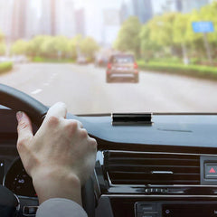Temporary Parking Card Phone Number Plate Display - Black parking number device placed on a car dashboard, hand holding steering wheel visible