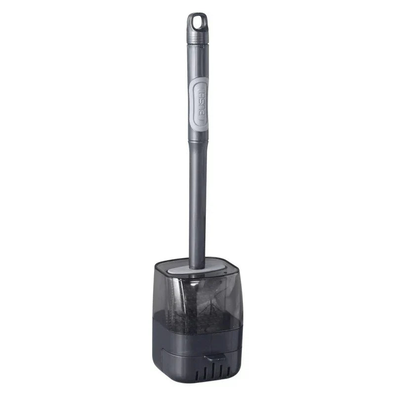 Toilet brush with long dark handle and attached translucent gray storage holder, upright on white background
