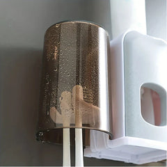 Rinse Cup - Close-up of amber translucent covered cup with water droplets, holding two manual toothbrushes next to the white and gray organizer base