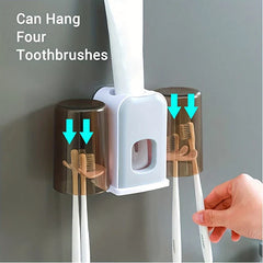 Rinse Cup - Hand placing a toothbrush into the holder, which holds two cups each with two toothbrushes and an inserted toothpaste tube
