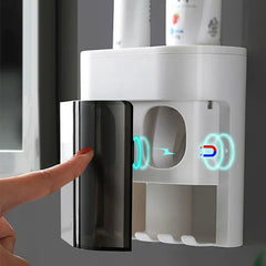 A finger opens a magnetic transparent door on a white bathroom wall organizer, toothpaste dispenser squeezer is not clearly visible.