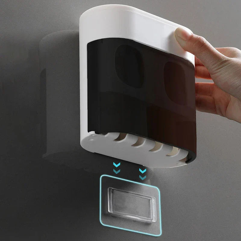 A hand holds a wall-mounted bathroom storage caddy above an adhesive wall mount, with toothbrush holder slots at the caddy's base.