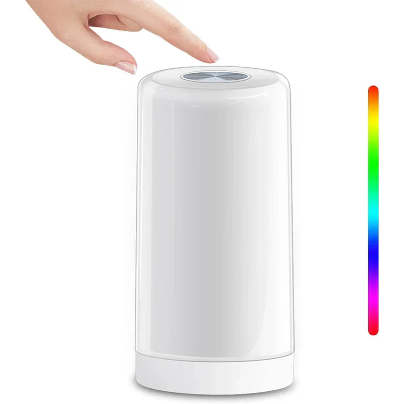 Led desk lamp with a hand above its top control, and a vertical rainbow color scale on the right