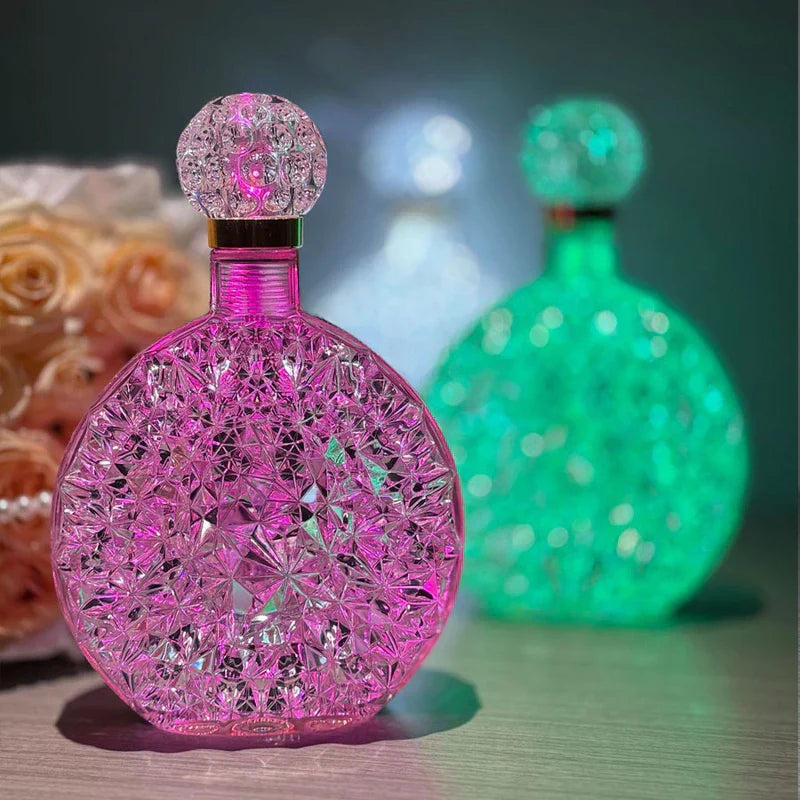 Pink faceted round led desk lamp in foreground, green glowing same-style lamp in soft focus background, rose decor to left