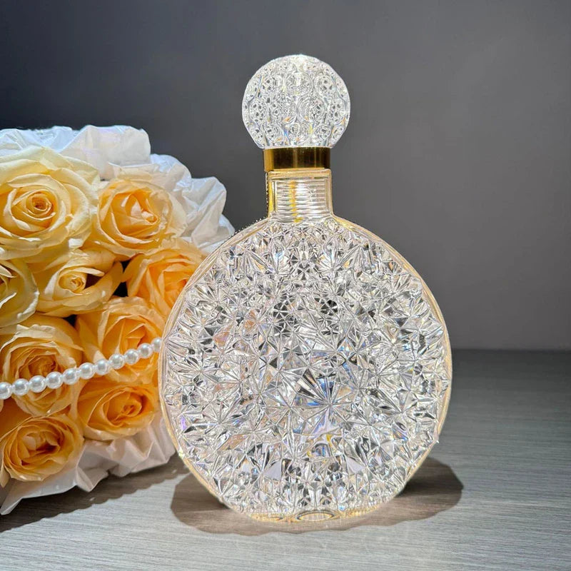 Clear diamond-cut round led desk lamp, yellow roses with pearl string decor beside it, on light wood surface