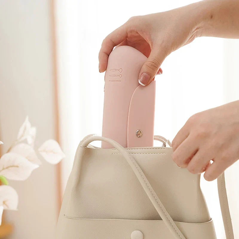 Makeup Brush Holder - Hand placing the light pink makeup brush case into a beige handbag