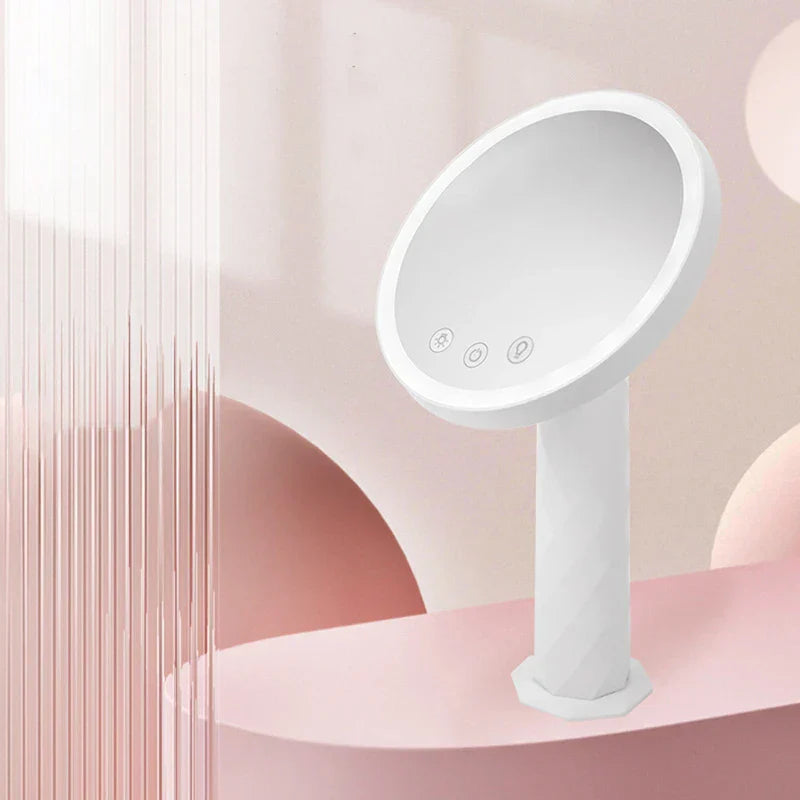 Weißer runder LED-Schminkspiegel mit drei Touch-Tasten auf der Spiegeloberfläche, auf rosa Plattform mit pastellfarbenem dekorativem Hintergrund präsentiert